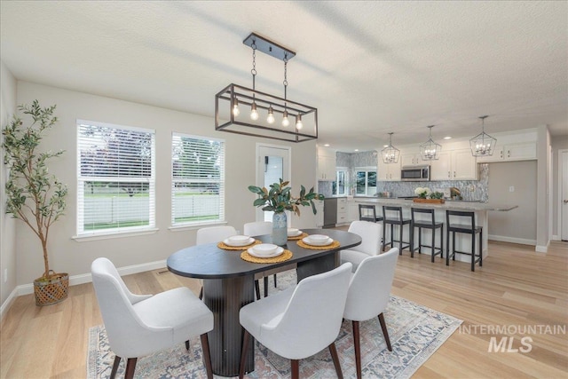 1499 E Sicily St, Meridian, ID 83642 - dining area featuring light wood-style floors, a textured ceiling, and healthy amount of natural light