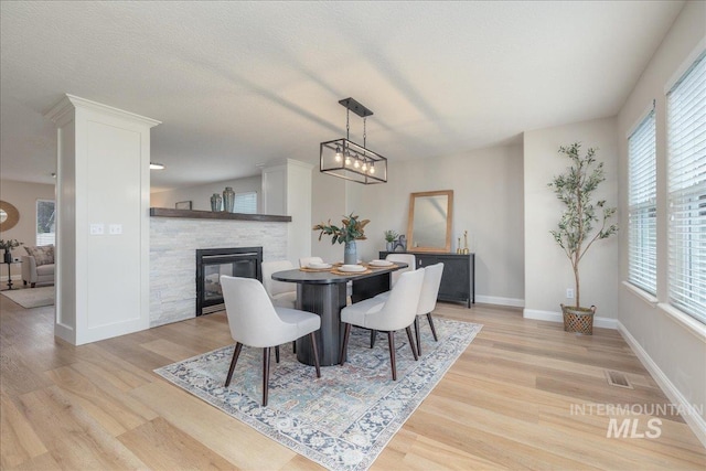 1499 E Sicily St, Meridian, ID 83642 - dining space with plenty of natural light, light wood finished floors, and a stone fireplace
