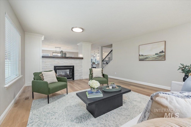 1499 E Sicily St, Meridian, ID 83642 - living room featuring wood finished floors, a fireplace, stairs, and a chandelier