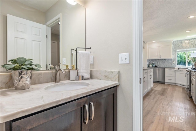 1499 E Sicily St, Meridian, ID 83642 - full bath with vanity, wood finished floors, backsplash, recessed lighting, and a textured ceiling