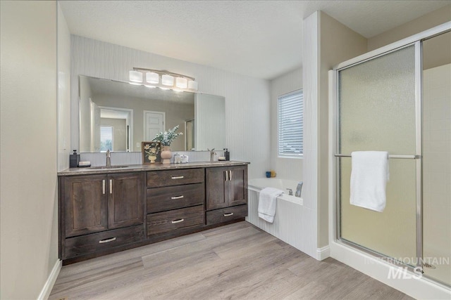 1499 E Sicily St, Meridian, ID 83642 - full bathroom with wood finished floors, a stall shower, a bath, double vanity, and plenty of natural light
