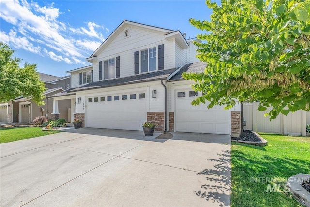 1499 E Sicily St, Meridian, ID 83642 - traditional home with stone siding, an attached garage, concrete driveway, and a front lawn