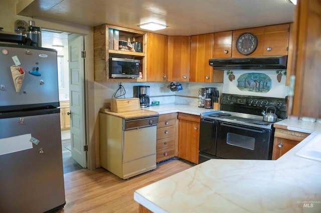 kitchen featuring appliances with stainless steel finishes, decorative backsplash, and light wood-type flooring