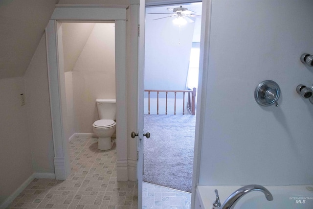 bathroom with toilet, a washtub, and ceiling fan