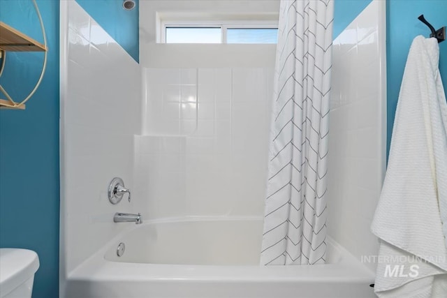 bathroom with toilet and shower / bathtub combination with curtain