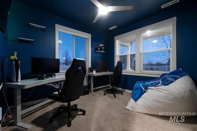 carpeted home office featuring ceiling fan