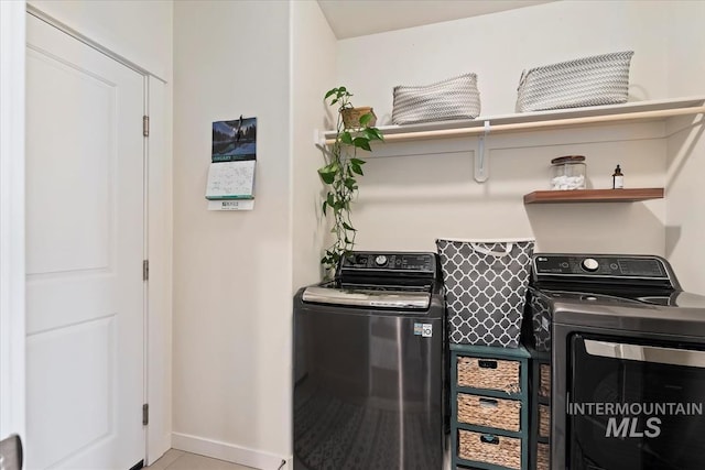 laundry room featuring tile patterned flooring and separate washer and dryer