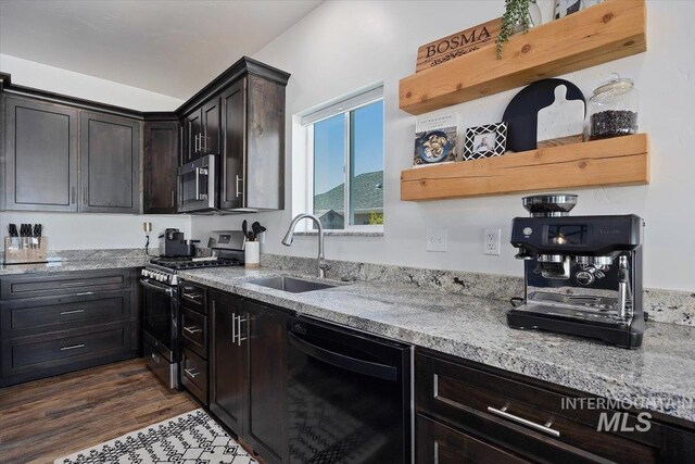 kitchen featuring light stone counters, appliances with stainless steel finishes, dark hardwood / wood-style floors, and sink