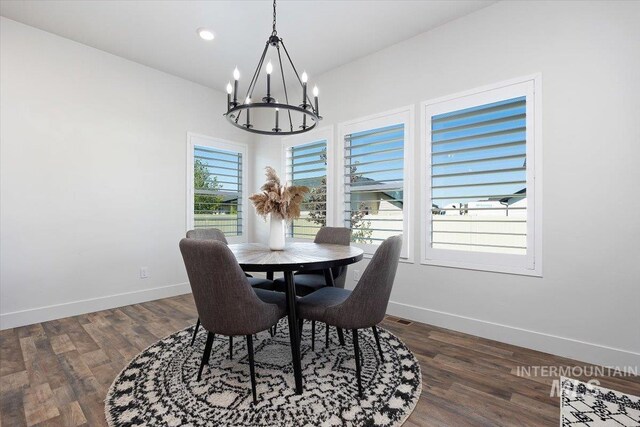 dining area with dark hardwood / wood-style flooring and a notable chandelier