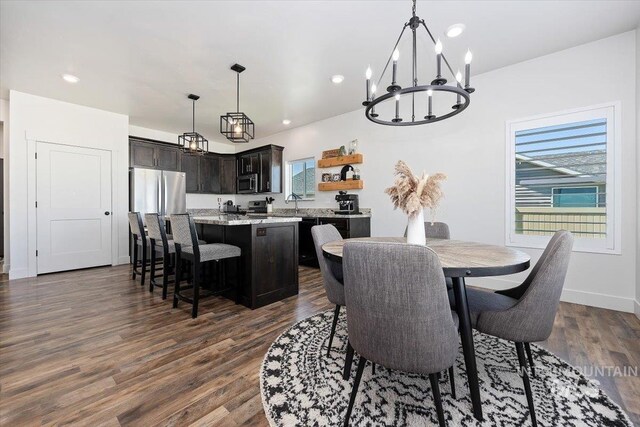 dining room featuring dark hardwood / wood-style flooring, sink, and a notable chandelier