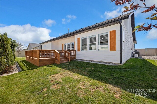 back of property featuring a yard and a wooden deck