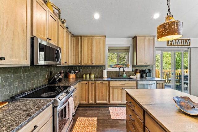 kitchen with tasteful backsplash, sink, dark hardwood / wood-style flooring, hanging light fixtures, and stainless steel appliances