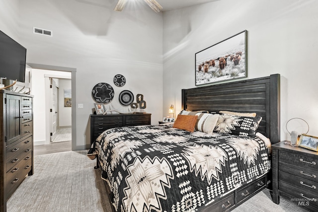 bedroom with a high ceiling and ceiling fan