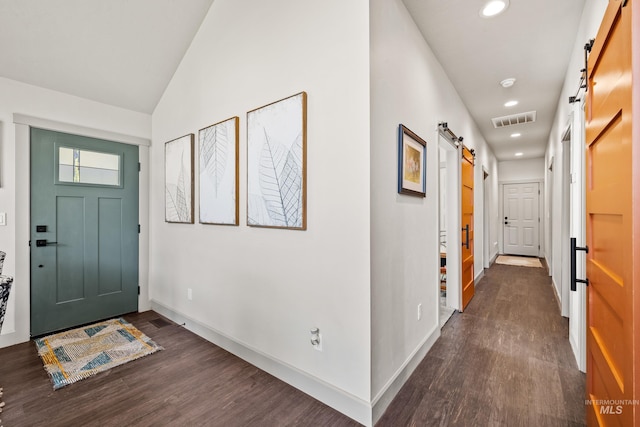 entrance foyer featuring a barn door, dark hardwood / wood-style floors, and lofted ceiling