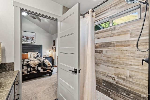 bathroom featuring walk in shower and lofted ceiling