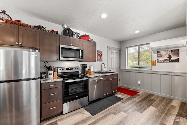 kitchen featuring dark brown cabinetry, appliances with stainless steel finishes, and sink