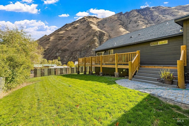 exterior space with a yard and a deck with mountain view