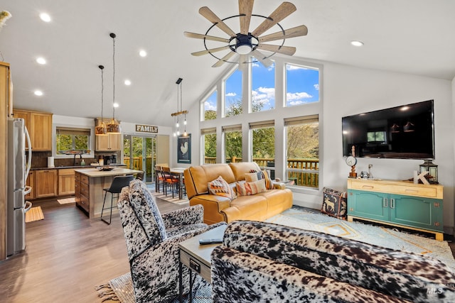 living room with ceiling fan, high vaulted ceiling, sink, and light hardwood / wood-style floors