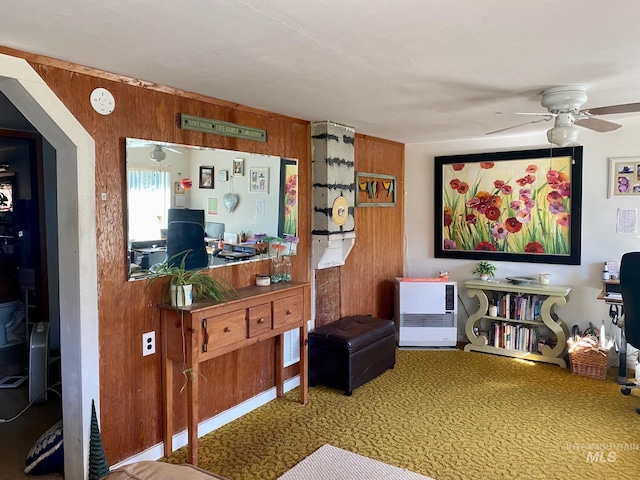 interior space featuring wooden walls and ceiling fan