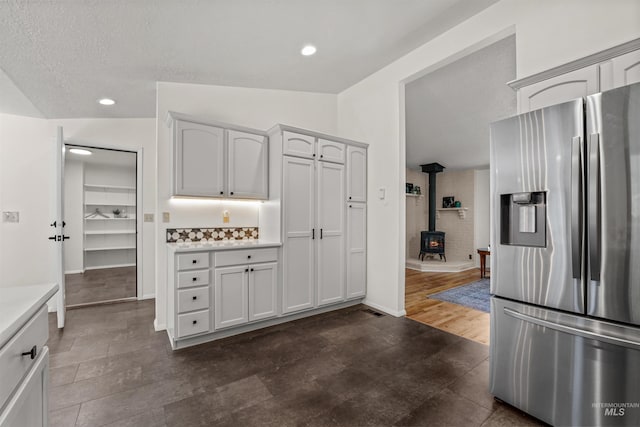 1913 W Suncrest Dr, Boise, ID 83705 - kitchen featuring stainless steel fridge with ice dispenser, light countertops, a wood stove, recessed lighting, and a textured ceiling