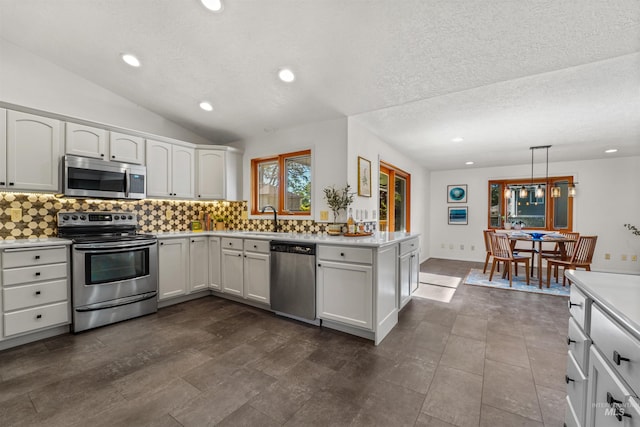 1913 W Suncrest Dr, Boise, ID 83705 - kitchen featuring appliances with stainless steel finishes, light countertops, backsplash, a sink, and a textured ceiling