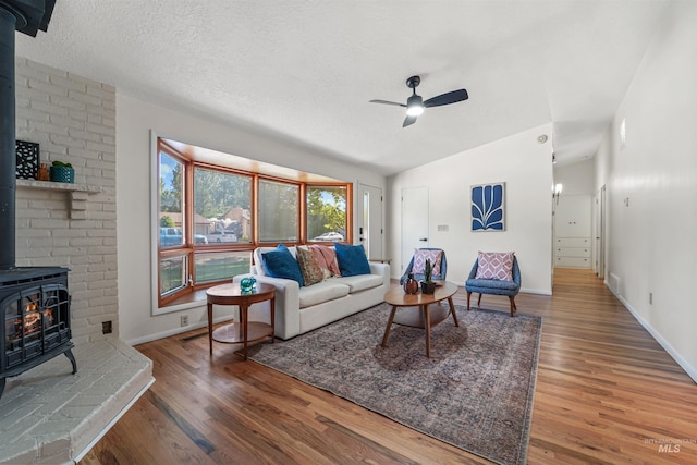 1913 W Suncrest Dr, Boise, ID 83705 - living room featuring a wood stove, lofted ceiling, wood finished floors, ceiling fan, and baseboards