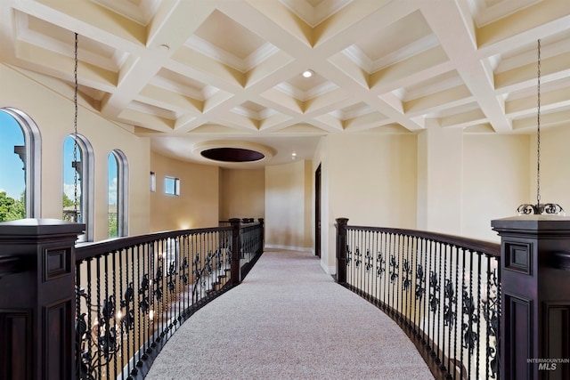 hall with coffered ceiling, beamed ceiling, baseboards, and carpet flooring