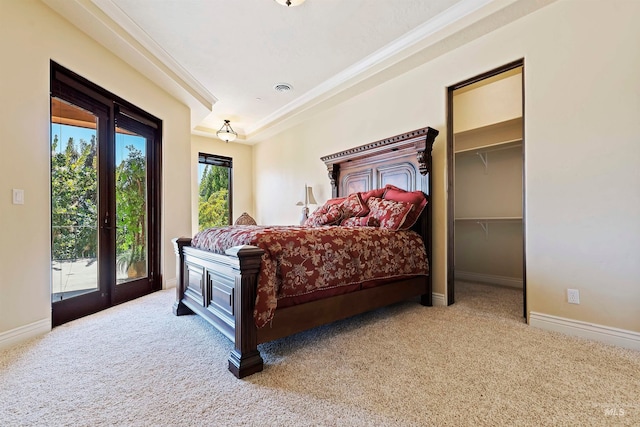 carpeted bedroom featuring access to exterior, a walk in closet, and baseboards
