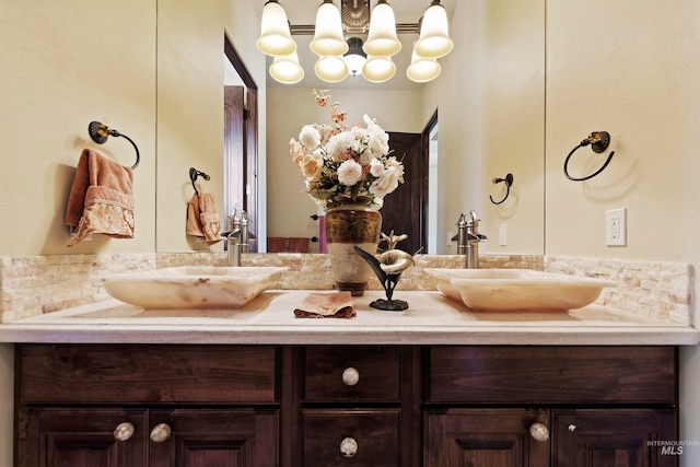full bathroom with double vanity and a chandelier