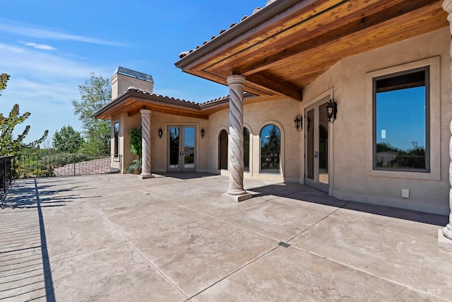 view of patio featuring french doors and fence