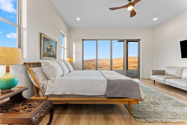 bedroom with access to outside, wood finished floors, and recessed lighting