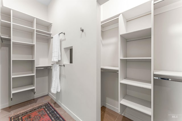 spacious closet featuring light tile patterned flooring