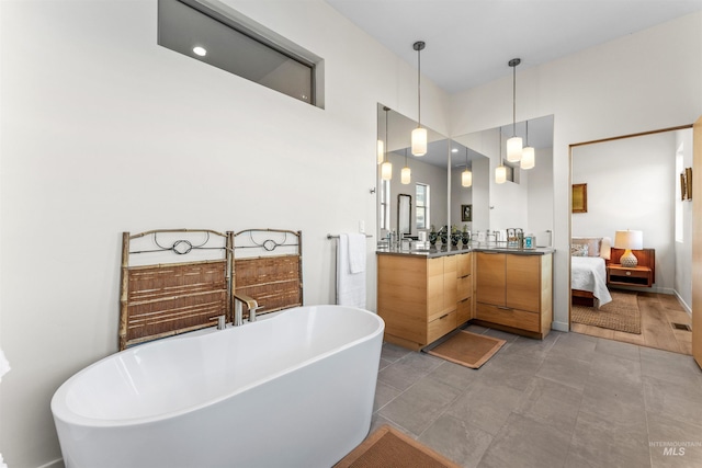 bathroom featuring a freestanding bath, connected bathroom, and vanity