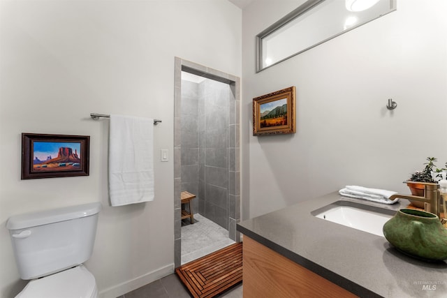 full bath with toilet, baseboards, tiled shower, and vanity