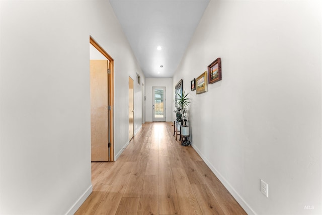 hall featuring light wood-style floors and baseboards