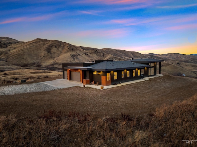 view of front facade featuring an attached garage, a mountain view, and concrete driveway