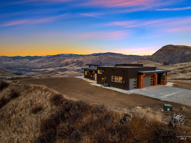 view of front of home featuring an attached garage, a mountain view, concrete driveway, and stucco siding