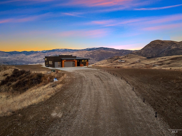 exterior space featuring driveway, a garage, and a mountain view