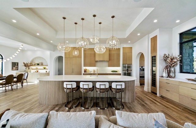 680 N Delehaye Ave, Eagle, ID 83616 - kitchen featuring light countertops, arched walkways, a tray ceiling, and modern cabinets