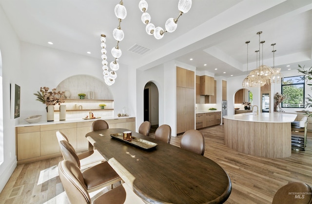 680 N Delehaye Ave, Eagle, ID 83616 - dining room featuring visible vents, light wood-style floors, recessed lighting, a tray ceiling, and arched walkways