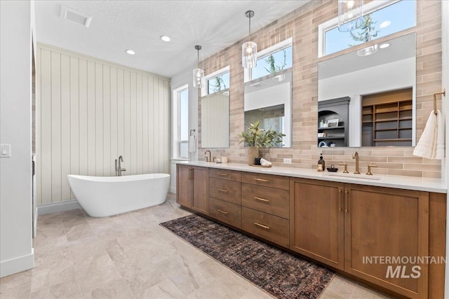 3436 N Mayberry Way, Eagle, ID 83616 - bathroom with double vanity, decorative backsplash, a freestanding tub, baseboards, and a sink