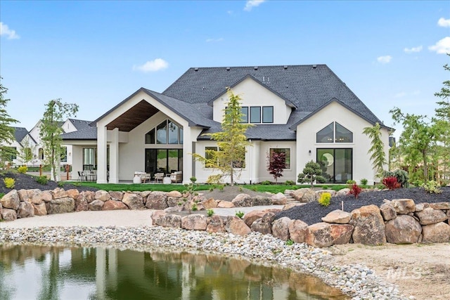 3436 N Mayberry Way, Eagle, ID 83616 - rear view of house with a shingled roof, a water view, stucco siding, and a patio area
