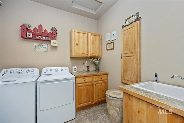 washroom featuring washer and dryer, attic access, cabinet space, and a sink