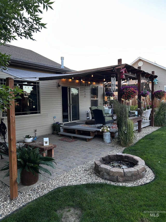 rear view of house featuring a patio area, an outdoor fire pit, and a yard