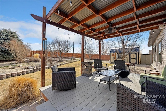 wooden deck featuring an outbuilding, a shed, outdoor lounge area, and a fenced backyard