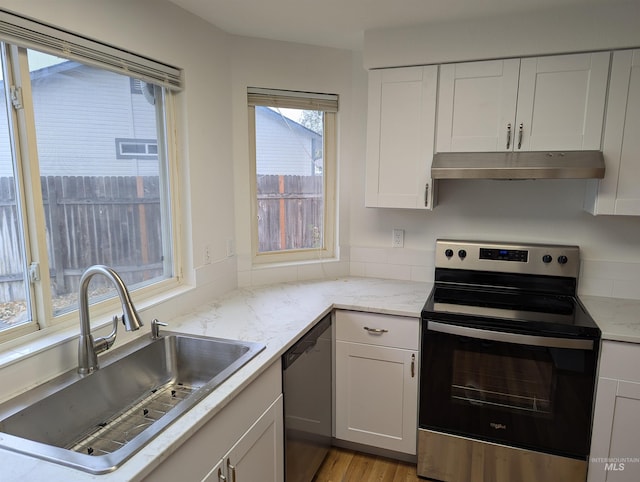 kitchen featuring appliances with stainless steel finishes, light hardwood / wood-style floors, white cabinetry, and sink