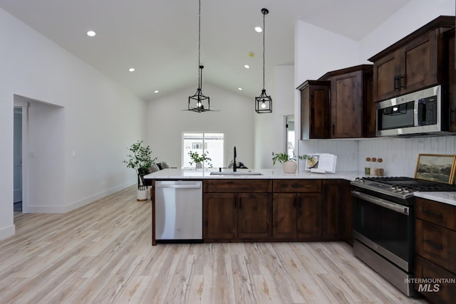 kitchen with dark brown cabinetry, sink, backsplash, and appliances with stainless steel finishes