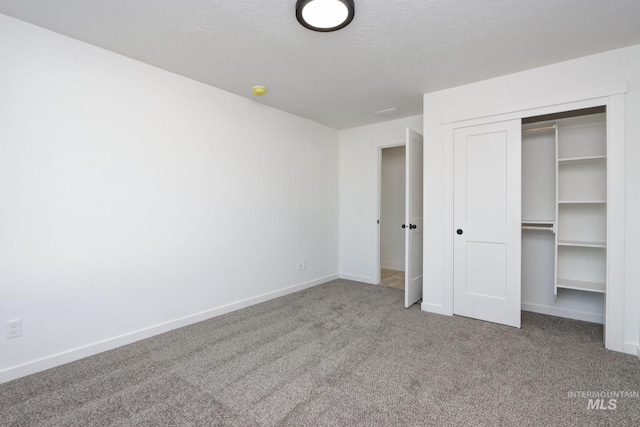 unfurnished bedroom featuring a closet, carpet flooring, and a textured ceiling