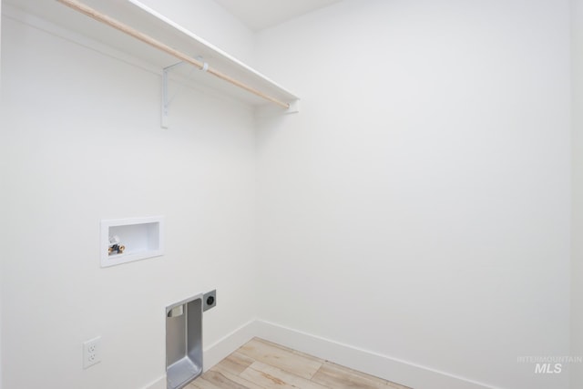 clothes washing area with hookup for a washing machine, hookup for an electric dryer, and light hardwood / wood-style floors