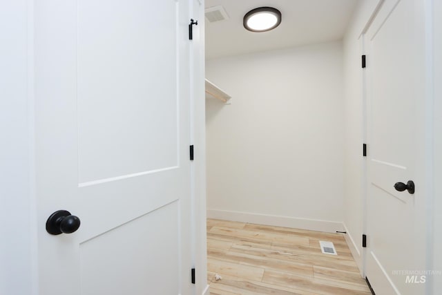 walk in closet with hardwood / wood-style flooring